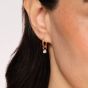 yellow gold hoop earrings with round light pink diamond drops on a woman's ear 