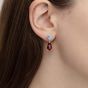 Close up of a ruby and diamond earrings on the ear