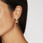 Model wearing a pair of earrings set with pear shape diamonds and a pear shape yellow diamond 